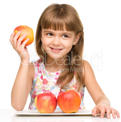 Little girl with red apples