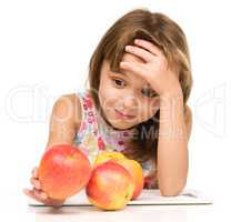 Little girl with red apples