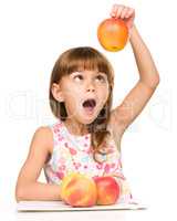 Little girl with apples is showing thumb up sign