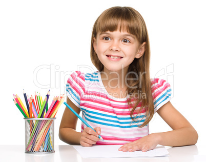 Little girl is drawing using pencils