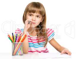 Little girl is drawing using pencils