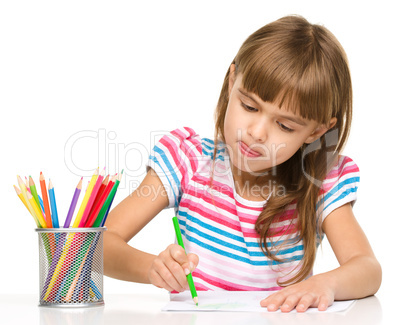 Little girl is drawing using pencils