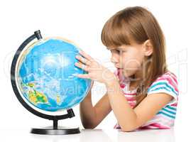 Little girl is examining globe
