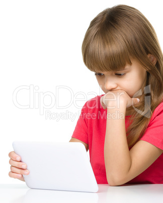 Young girl is using tablet while studying