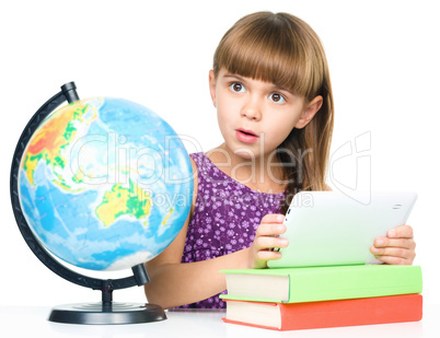 Young girl is using tablet while studying