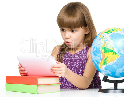 Young girl is using tablet while studying