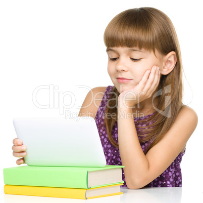 Young girl is using tablet while studying