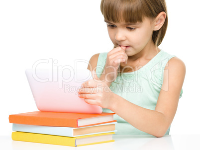 Young girl is using tablet while studying