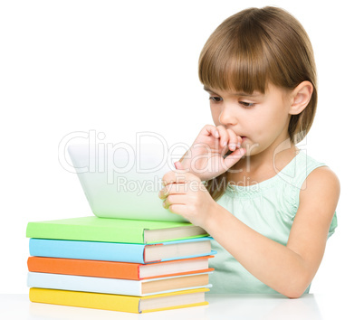 Young girl is using tablet while studying