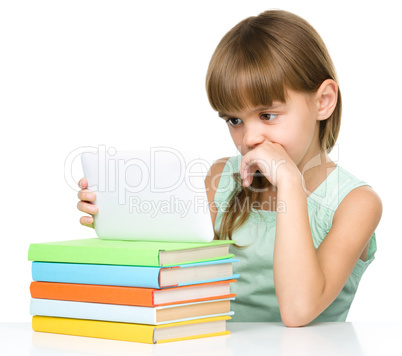 Young girl is using tablet while studying