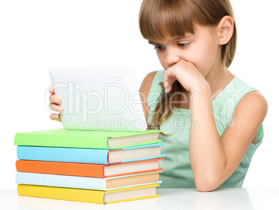 Young girl is using tablet while studying