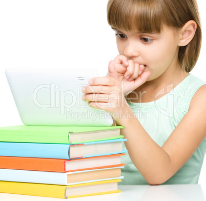 Young girl is using tablet while studying