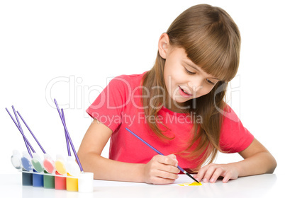 Little girl is painting with gouache