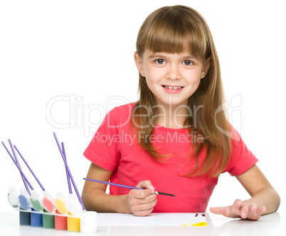 Little girl is painting with gouache