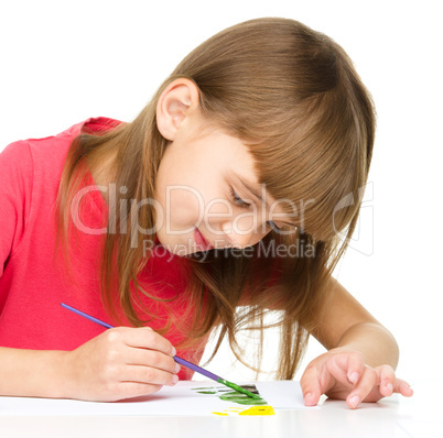 Little girl is painting with gouache