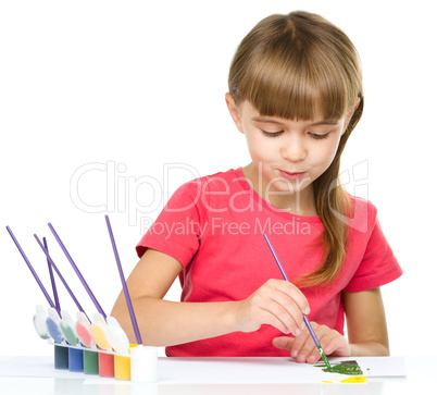 Little girl is painting with gouache