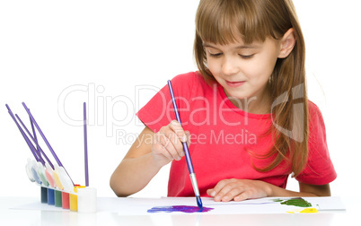 Little girl is painting with gouache