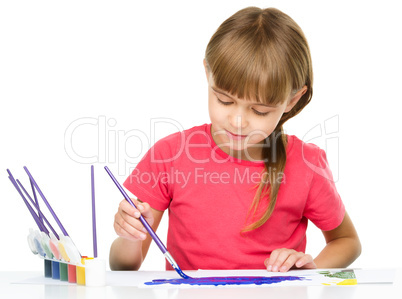 Little girl is painting with gouache