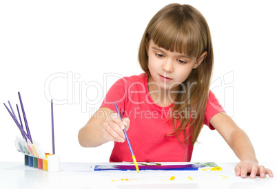 Little girl is painting with gouache