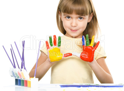 Portrait of a cute girl playing with paints