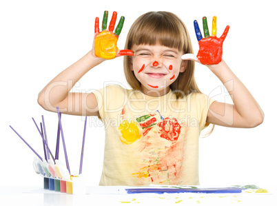 Portrait of a cute girl playing with paints