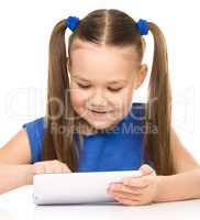 Young cheerful girl is using tablet