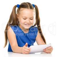 Young cheerful girl is using tablet