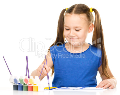 Little girl is painting with gouache