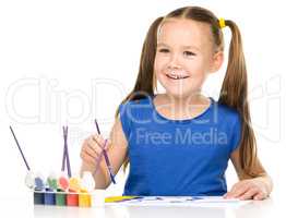 Little girl is painting with gouache