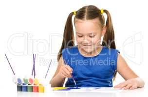 Little girl is painting with gouache