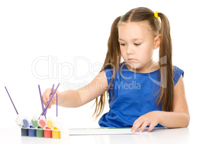 Little girl is drawing using pencils
