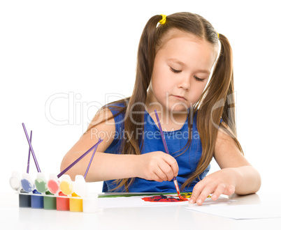 Little girl is painting with gouache