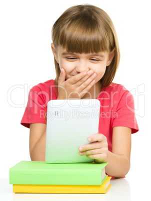 Young girl is using tablet while studying