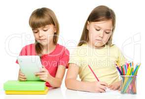 Children with tablet and color pencils