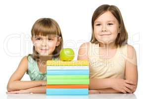 Little girls with books and apple