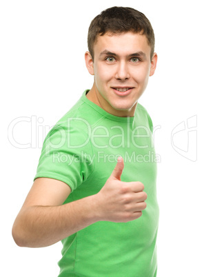 Cheerful young man showing thumb up sign