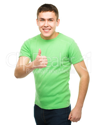 Cheerful young man showing thumb up sign