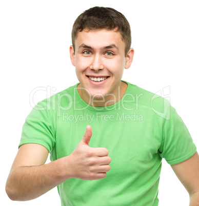 Cheerful young man showing thumb up sign