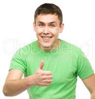 Cheerful young man showing thumb up sign