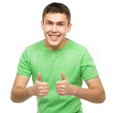 Cheerful young man showing thumb up sign