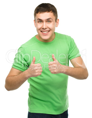 Cheerful young man showing thumb up sign