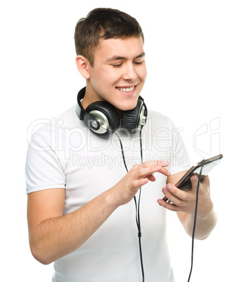 Young man enjoying music using headphones