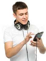 Young man enjoying music using headphones