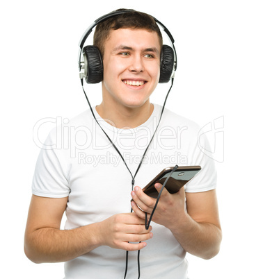 Young man enjoying music using headphones