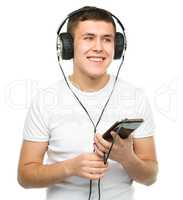 Young man enjoying music using headphones