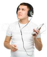 Young man enjoying music using headphones