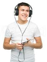 Young man enjoying music using headphones