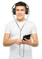 Young man enjoying music using headphones