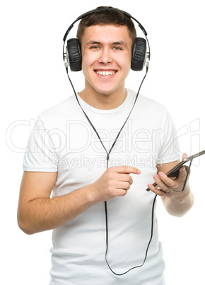 Young man enjoying music using headphones