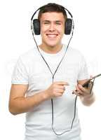 Young man enjoying music using headphones